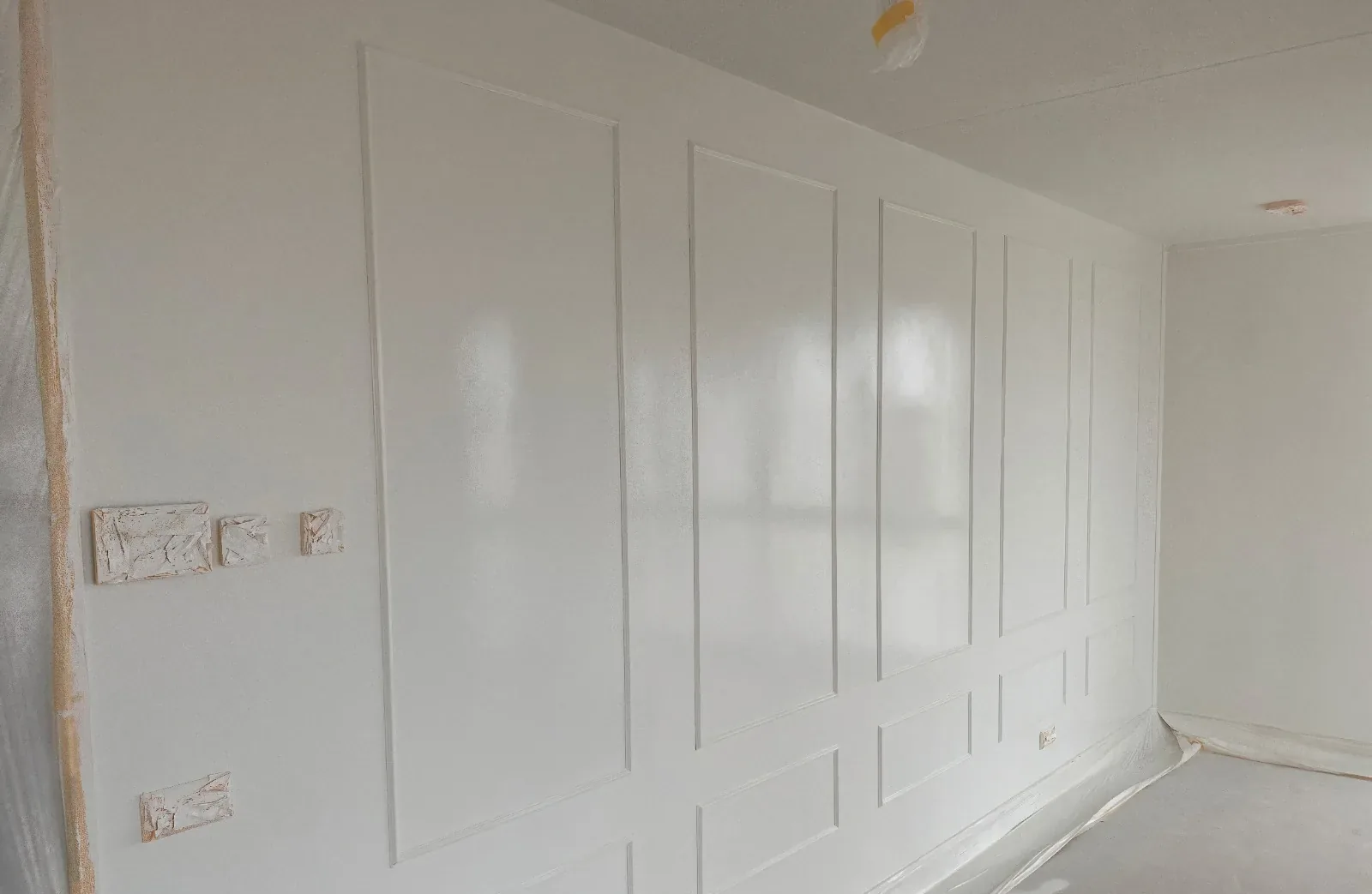 Na: strak afgewerkte wand met paneelwerk door DOEE